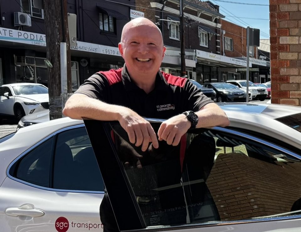 Russell standing beside a St George Community vehicle.
